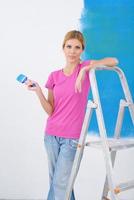 mujer sonriente feliz pintando el interior de la casa foto