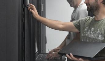 Technicians team updating hardware inspecting system performance in super computer server room or cryptocurrency mining farm. photo