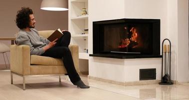 young man at home reading book photo