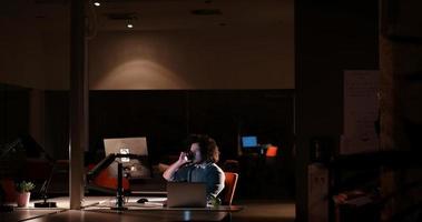 man working on computer in dark office photo