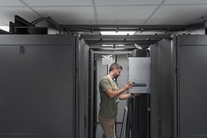 IT engineer working In the server room or data center The technician puts in a rack a new server of corporate business mainframe supercomputer or cryptocurrency mining farm. photo