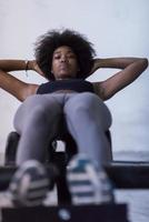 black woman doing sit ups at the gym photo