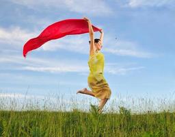 beautiful woman with red scarf on meadow photo