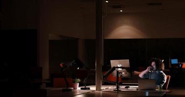 man working on computer in dark office photo