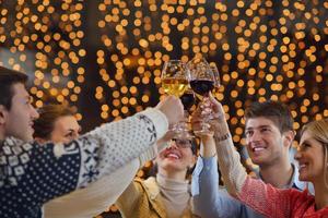 grupo de jóvenes felices beben vino en la fiesta foto