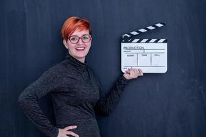 redhead woman holding movie clapper photo