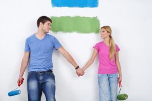 happy couple paint wall at new home photo