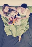 happy young family eat breakfast in bed photo