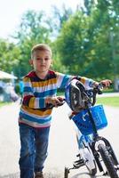 niño feliz aprendiendo a andar en bicicleta foto