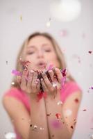 woman blowing confetti in the air photo