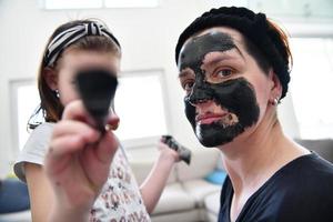 mother and daughter at home making facial mask beauty treatment photo