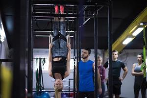 mujer trabajando con entrenador personal en anillos de gimnasia foto