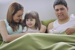 happy family relaxing in bed photo