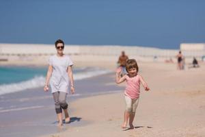 mother and daughter running on the beach photo