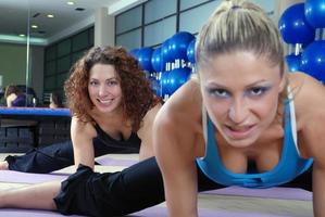 hermosas chicas jóvenes haciendo ejercicio en un gimnasio foto