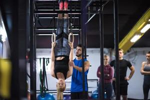 mujer trabajando con entrenador personal en anillos de gimnasia foto