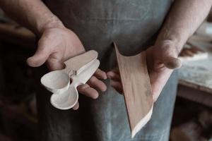 Spoon master in his workshop with wooden products and tools photo