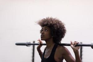 black woman lifting empty bar photo