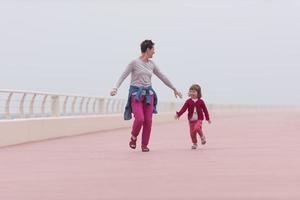 madre y niña linda en el paseo marítimo junto al mar foto