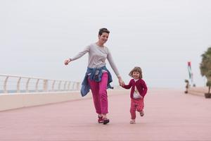 mother and cute little girl on the promenade by the sea photo