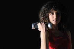 youg woman workout in fitness club with dumbbell photo