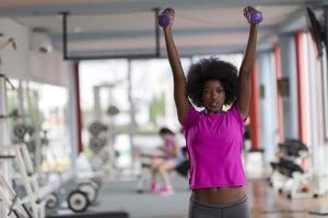 woman working out in a crossfit gym with dumbbells photo