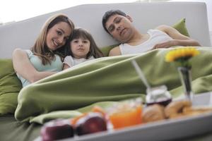 happy young family eat breakfast in bed photo