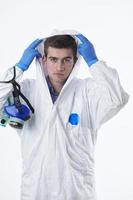 Doctor wearing protective biological suit and mask due to coronavirus white background photo