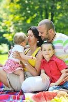 Feliz pareja joven con sus hijos divertirse en el parque foto