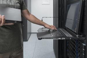 Close up on Data Center Engineer hands Using keyboard on a supercomputer Server Room Specialist Facility with Male System Administrator Working with Data Protection Network for Cyber Security. photo