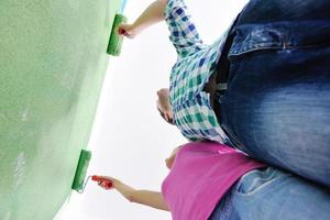 happy couple paint wall at new home photo