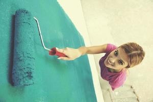 mujer sonriente feliz pintando el interior de la casa foto