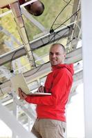 engineer using laptop at solar panels plant field photo