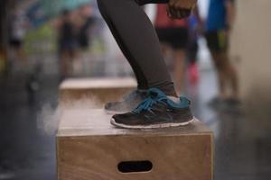 black woman is performing box jumps at gym photo