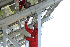 ingeniero que usa una computadora portátil en el campo de la planta de paneles solares foto