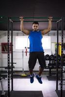 man doing pull ups on the horizontal bar photo