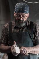 Spoon master in his workshop with wooden products and tools photo