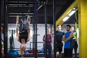 mujer trabajando con entrenador personal en anillos de gimnasia foto