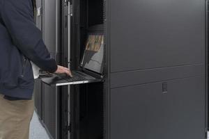 Close up on Data Center Engineer hands Using keyboard on a supercomputer Server Room Specialist Facility with Male System Administrator Working with Data Protection Network for Cyber Security. photo