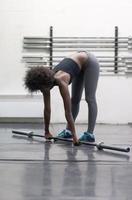 black woman lifting empty bar photo