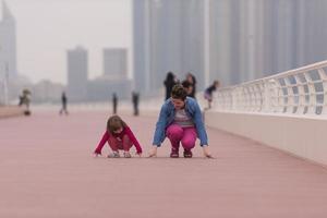 madre y niña linda en el paseo marítimo foto