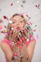 woman blowing confetti in the air