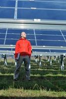 engineer using laptop at solar panels plant field photo