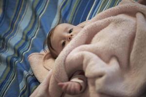 cute little baby playing with hands and smiling photo