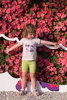 niña linda en un jardín de flores foto