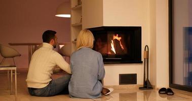 Young couple sitting in front of fireplace photo