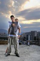 romantic urban couple dancing on top of  bulding photo