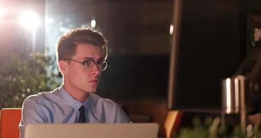 man working on computer in dark office photo