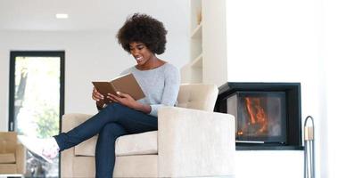 mujer negra en casa leyendo un libro foto