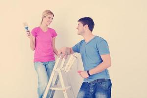 happy couple paint wall at new home photo